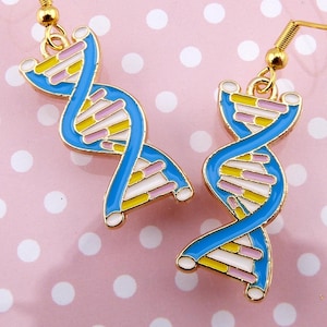 May include: A pair of gold-tone earrings with a blue and yellow DNA double helix design. The earrings are on a pink background with white polka dots.