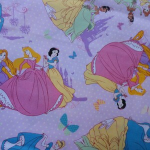 Pu&ograve; includere: Un tessuto rosa e viola con un motivo ripetitivo di principesse Disney. Le principesse indossano i loro abiti caratteristici e sono circondate da farfalle e castelli.