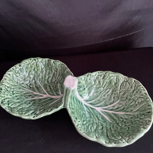 May include: A green ceramic serving dish shaped like a cabbage with two separate bowls. The dish is perfect for serving snacks or dips.