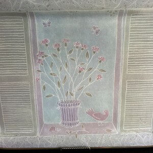 May include: A white ceramic tray with a pastel blue and pink floral design. The tray features a window scene with a bouquet of pink flowers in a purple pot, a bird, and a snail. The tray is signed "Camatte" in the bottom left corner.