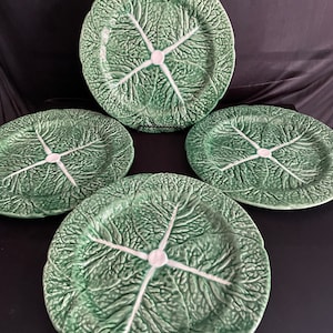 May include: Set of four green cabbage leaf ceramic dinner plates with white centers.