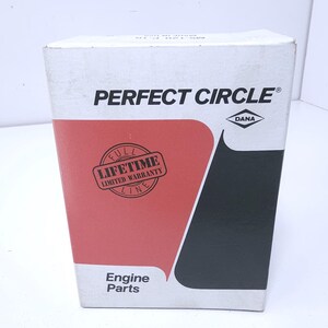 May include: A rectangular white cardboard box for Perfect Circle engine parts. The front features a red graphic area, a black section, and a circular stamp that reads Full Lifetime Limited Warranty Line. The Dana logo is printed in black.