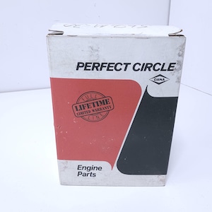 May include: A rectangular white cardboard box for Perfect Circle engine parts. The front features a red and black graphic design, the text PERFECT CIRCLE, a DANA logo, and a circular stamp that reads FULL LIFETIME LIMITED WARRANTY LINE.