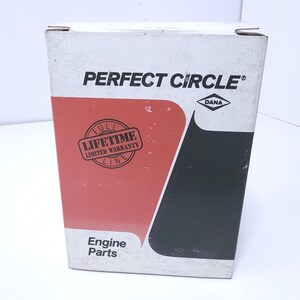 May include: A rectangular white cardboard box for Perfect Circle engine parts. The front features a red and black graphic design, the text PERFECT CIRCLE, a Dana logo, and a circular stamp that reads FULL LIFETIME LIMITED WARRANTY LINE.
