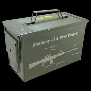 May include: An olive green metal ammunition box with a handle. The box features the text "Anatomy of A Pew Pewer" with a diagram of a rifle and labels. The box has a hinged lid and a latch on the side.