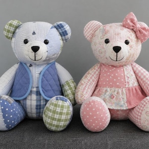May include: Two plush teddy bears made of patchwork fabric. The left bear features blue, white, and green plaid and star patterns with a blue quilted vest. The right bear features pink and white floral, heart, and gingham patterns with a pink bow.