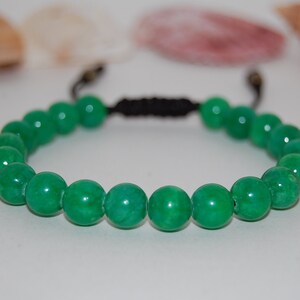 Puede incluir: Un brazalete de cuentas de jade verde con cierre de cordón negro.