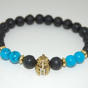 May include: Black lava rock and turquoise bead bracelet with a gold gladiator helmet charm.