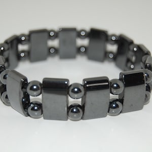 May include: A black hematite bracelet with rectangular and round beads.