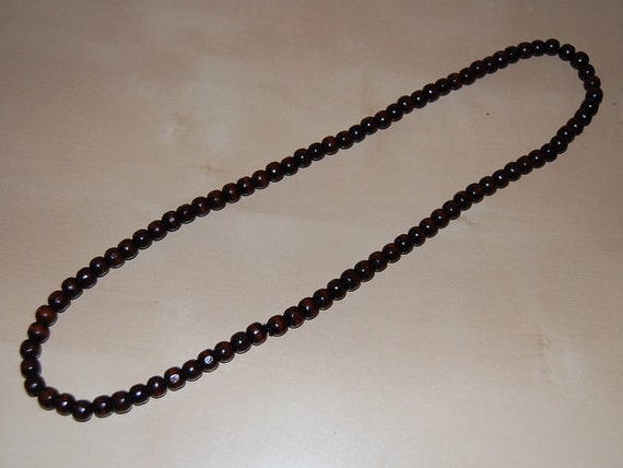 Collana lunga con perline ovali e rotonde in legno nero e