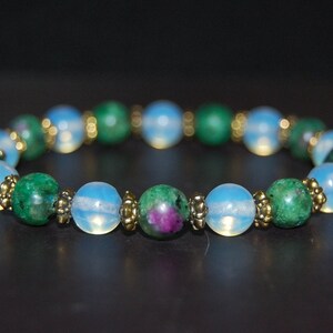 Könnte beinhalten: Ein Armband aus grünen und blauen Edelsteinperlen. Das Armband hat goldene Akzente zwischen jeder Perle.