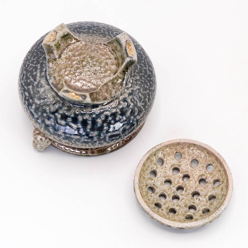 Bottom view of tripod incense burner showing three legs and unglazed base typical of Mashiko ware