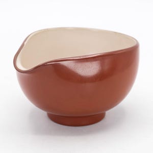 May include: A brown ceramic mixing bowl with a white interior and a pouring spout. The bowl has a glossy finish.