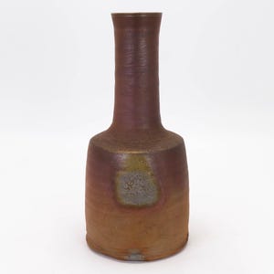 May include: A brown ceramic vase with a narrow neck and a wide base. The vase has a mottled glaze with shades of brown, purple, and gold.