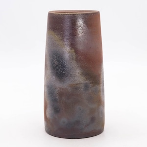 Peut inclure: Un vase cylindrique artisanal avec une surface texturée. Le vase présente un dégradé de couleurs, notamment du marron, du noir et des touches de jaune. Le vase mesure environ 20 cm de haut, parfait pour exposer des fleurs ou comme pièce décorative.