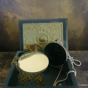 Könnte beinhalten: Set aus drei Keramikbechern mit gesprenkelter, matter Oberfläche. Die Becher sind in Creme-, Hellgrau- und Dunkelgrautönen gehalten. Jede Tasse hat ein schlichtes, minimalistisches Design.