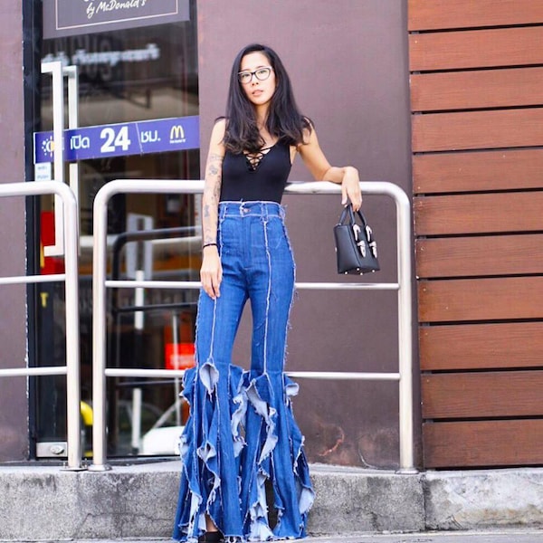 Calça jeans flare de cintura alta com franjas, estilo anos 70.