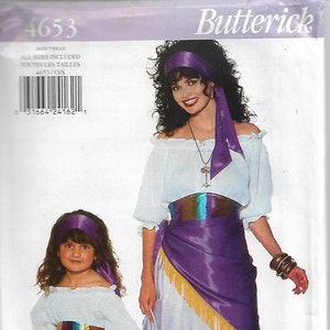 May include: A costume pattern featuring two people in matching outfits. The costumes include white off-the-shoulder tops, purple skirts with gold fringe, and matching headbands. The pattern is labeled "Butterick 4653".
