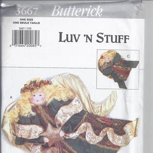 May include: Butterick sewing pattern for a decorative angel, labeled "Luv 'N Stuff." The angel has blonde hair, a star, and wears a green and gold outfit with red accents. The pattern includes multiple views of the angel.