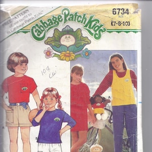 Puede incluir: Patrón de costura Butterick vintage para conjuntos de Cabbage Patch Kids. El patrón presenta ilustraciones de niños vistiendo los conjuntos. Incluye el logotipo de Cabbage Patch Kids y el texto "BONUS! Iron-on Transfers Included."
