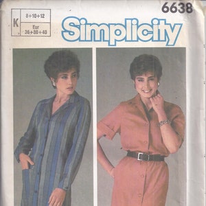 May include: Simplicity sewing pattern featuring two dress designs. One dress is a long-sleeved, button-down style with blue and gray vertical stripes. The other is a short-sleeved, button-down dress in a solid peach color, with a black belt.