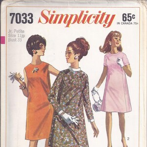 May include: Vintage Simplicity sewing pattern 7033 featuring three women in dresses. The pattern cover includes the text "Simplicity" and "Jr. Petite Size 11jp Bust 33". The dresses are in orange, floral print, and pink.