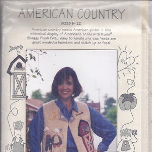 May include: A woman wearing a beige vest with whimsical Americana designs. The vest features appliqued figures, a barn, and a moon. The text "AMERICAN COUNTRY" and "SIZES 6-22" are visible.