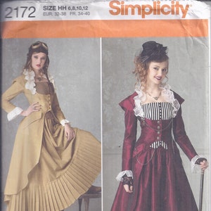 May include: Simplicity sewing pattern 2172 featuring two Victorian-style dresses. One dress is tan with a pleated skirt, the other is burgundy with a black and white striped bodice and pleated skirt. The pattern includes sizes 6, 8, 10, and 12.