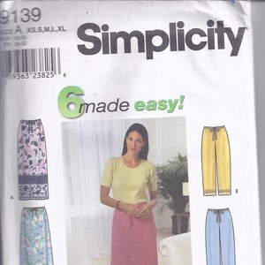 May include: Simplicity sewing pattern 9139 featuring six easy-to-make skirt and pants designs. The pattern includes a long pink skirt, yellow pants, and blue pants. The text "6 made easy!" is visible.