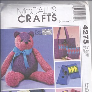 May include: McCall's Crafts sewing pattern featuring a teddy bear, tote bag, pouches, and other fabric crafts. The pattern includes a large teddy bear with a blue bow, and various accessories with geometric designs.