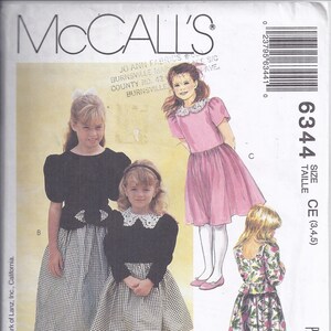 May include: McCall's sewing pattern for girls' dresses. The pattern features illustrations of several dress designs, including a black top with a gingham skirt, and a pink dress with a white collar. The pattern includes the Lanz for girls logo.