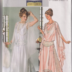 May include: Butterick sewing pattern B4093 for a 1914 style dress. The envelope features illustrations of two floor-length gowns with V-necklines, sheer draped sleeves, and decorative waist panels. One gown is white, and the other is a soft peach color.