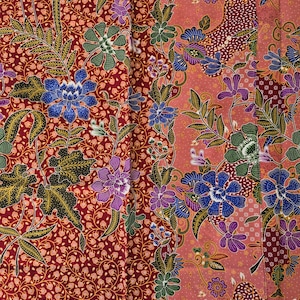 May include: A colourful textile with a floral design in red, pink, blue, green, and purple. The pattern showcases large, stylised flowers and detailed leaf motifs, creating a rich and textured visual appearance.