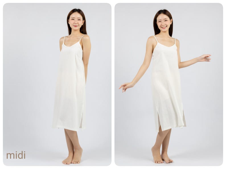 May include: A white midi slip dress with thin straps. The dress has a straight silhouette and a slightly flared hem. The model is wearing the dress with a relaxed, casual pose.
