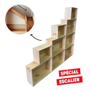 May include: A wooden shelf unit designed to fit under a staircase. The shelf unit is made of natural wood and has a simple, modern design. The shelf unit is labeled "SPECIAL ESCALIER".