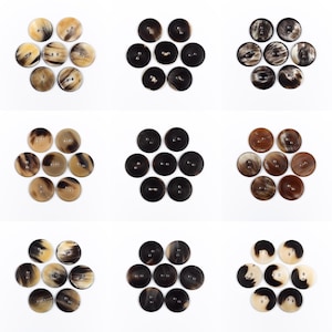 Könnte beinhalten: Neun Sätze runder Knöpfe in verschiedenen Braun-, Schwarz- und Cremetönen, angeordnet in Blumenmustern auf weißem Hintergrund. Jeder Knopf hat zwei Löcher zum Annähen. Die Knöpfe variieren in Farbe und Muster.