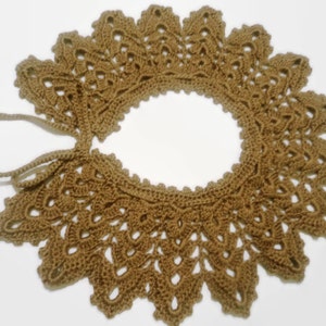 May include: A brown crocheted collar with a delicate lace pattern and a tie closure.