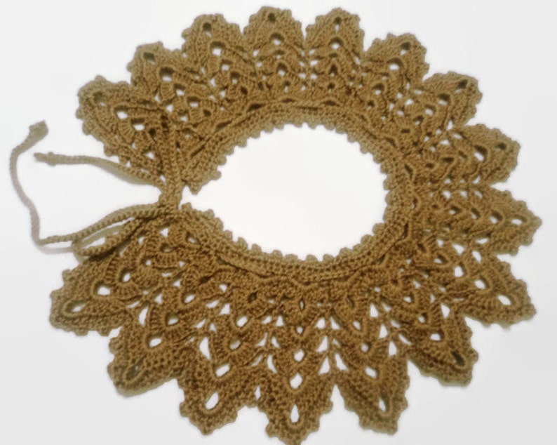 May include: A brown crocheted collar with a delicate lace pattern and a tie closure.