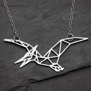 Collar de dinosaurio de plata con diseño geométrico de pterodáctilo y parque jurásico