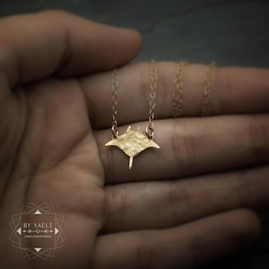 Colar com pingente de arraia-manta, colar dourado com pingente de arraia-manta e oceano.