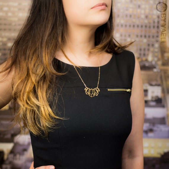 ゴールドの幾何学模様のネックレス。現代女性のための大胆な