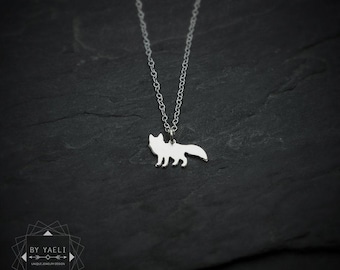 May include: A silver-toned necklace featuring a small, flat fox-shaped pendant suspended from a delicate chain. The pendant is a solid silhouette of a standing fox. The text "BY YAELI" and "UNIQUE JEWELRY DESIGN" is visible in the bottom corner.