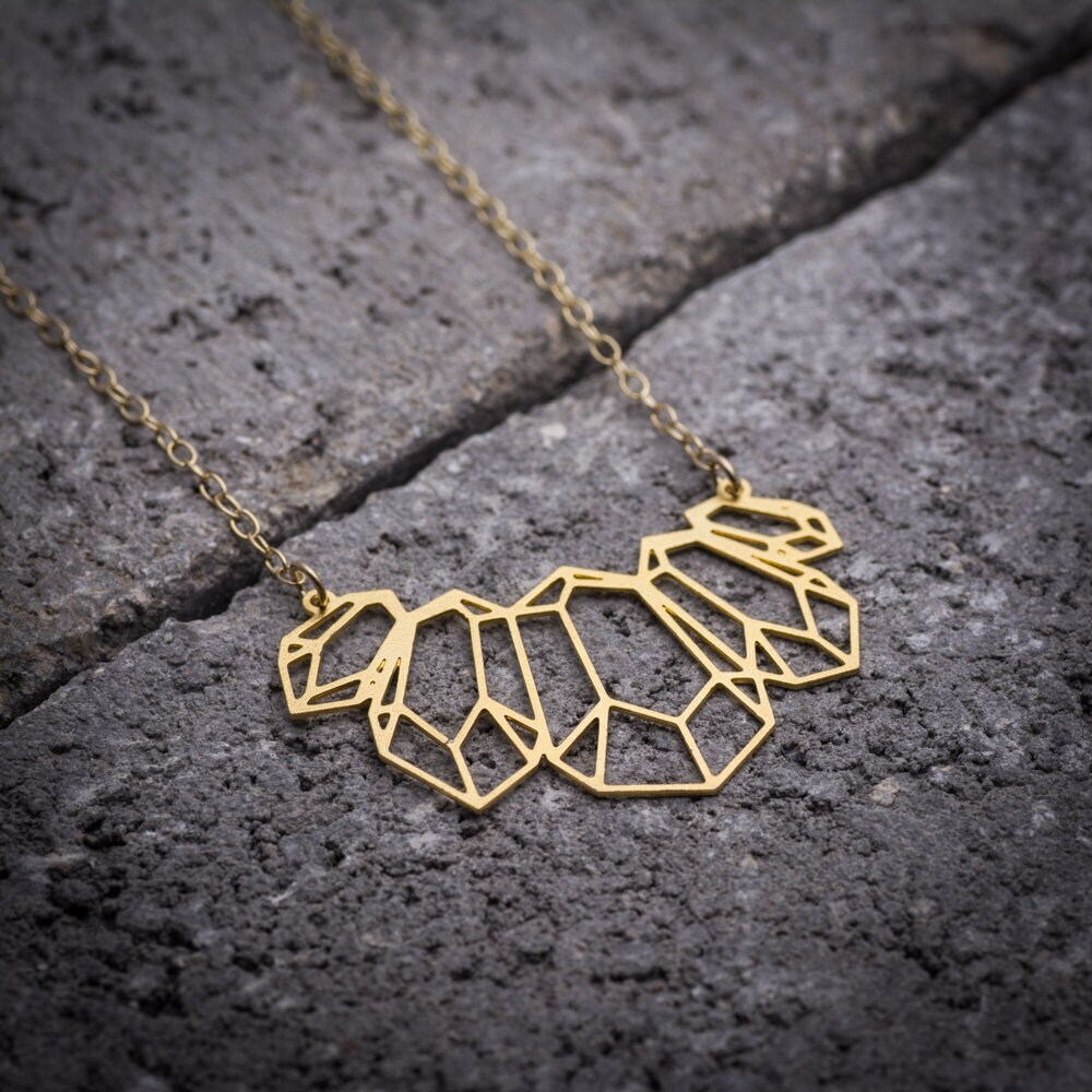ゴールドの幾何学模様のネックレス。現代女性のための大胆な
