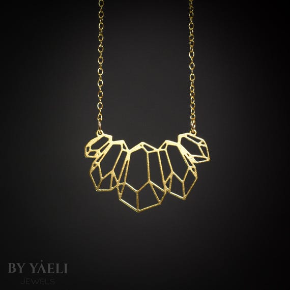 ゴールドの幾何学模様のネックレス。現代女性のための大胆な