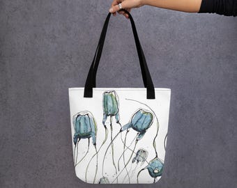 May include: A white tote bag with black handles features a watercolor illustration of blue and green jellyfish. The jellyfish are depicted with long, flowing tentacles.