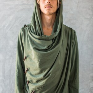 May include: A green hooded long-sleeved shirt with a draped cowl neck and wooden button closures.