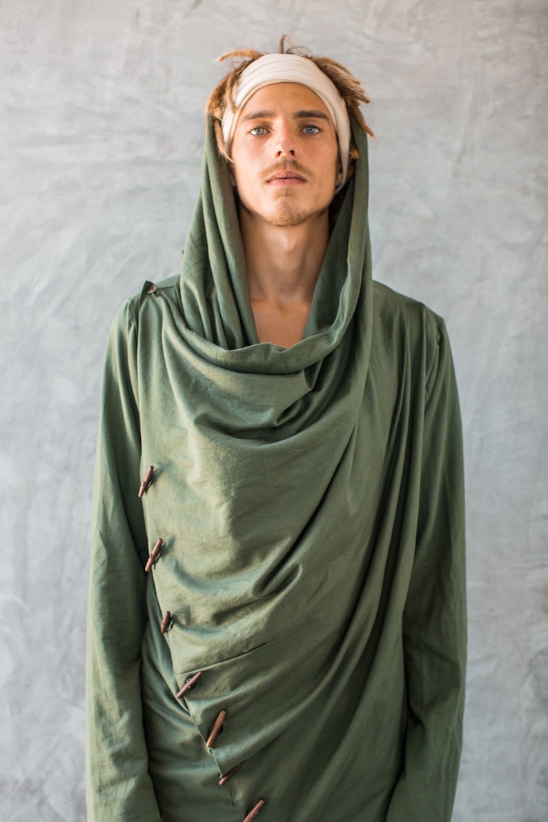 May include: A green hooded long-sleeved shirt with a draped cowl neck and wooden button closures.