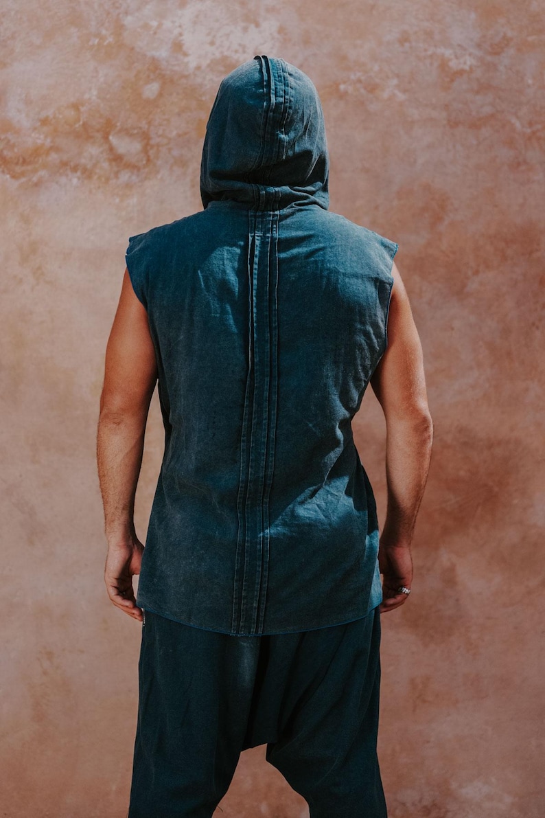 May include: A sleeveless hooded top and matching pants in a muted teal color. The top features a vertical seam detail down the back. The outfit is made of a soft, textured fabric, perfect for casual wear.