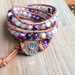 May include: A multi-strand leather wrap bracelet with purple and white agate beads and a silver button closure.