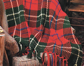 May include: A red, green, and blue plaid blanket with fringe, draped over a patterned armchair. The blanket features a classic tartan design with a repeating pattern of intersecting lines and blocks of color. The fringe is a mix of red, blue, and green.